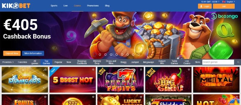 First page of the casino Kikobet featuring colorful graphics with a cashback bonus offer at the front. In the middle, there is game categories and images of different titles at the bottom.